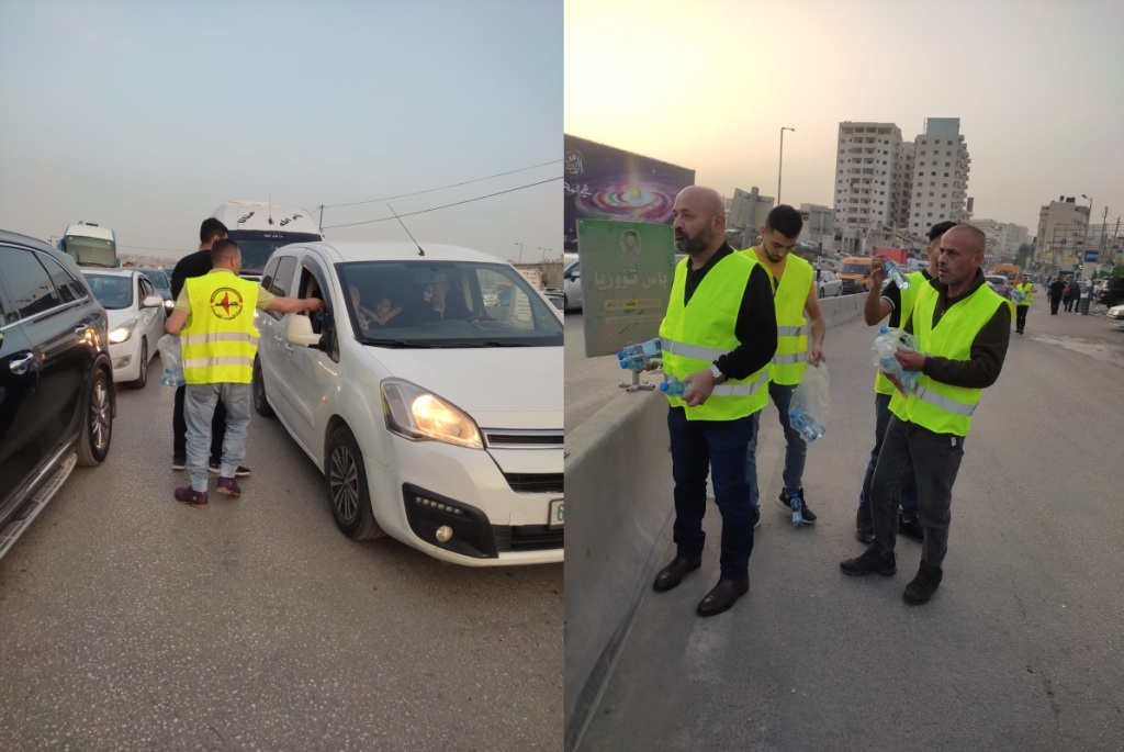 متطوعو النضال الشعبي يوزعون الماء والتمر على المواطنين على حاجز قلنديا